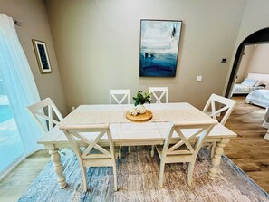 A dining area with a table, chairs, and a painting on the wall. - Coastal Paradise Near the Beach - Private Heated Pool - 4BR Marco Island Retreat (Marco Island)