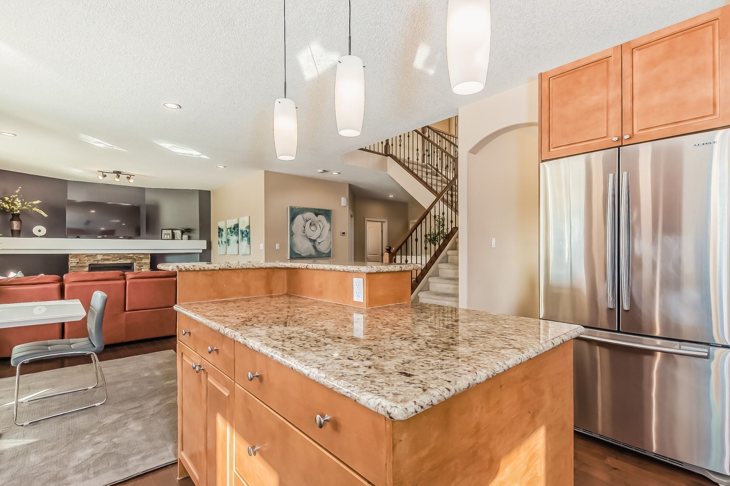 A modern kitchen with granite countertops, stainless steel appliances, and a built-in island.