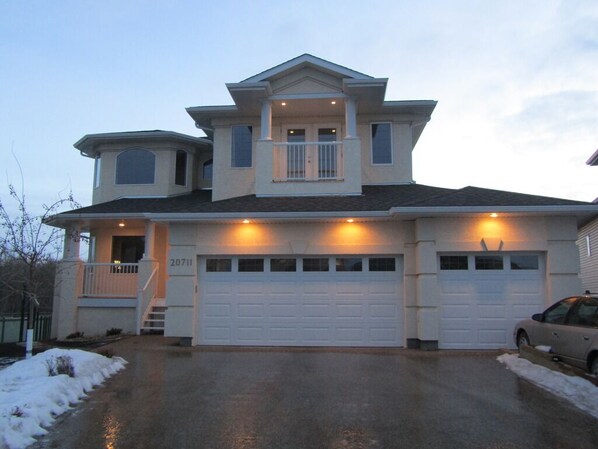 A two-story house with a garage, a covered porch, and a small balcony. - Million Dollar Home In Lewis Estaes Golf Course By Henday/Whitemud with Garage! (Edmonton)