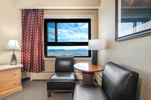 A hotel room with a bed, a desk, a chair, a lamp, a window with a mountain view, and a framed picture on the wall. - Charming resort at the mountain at Lake Tahoe, near casinos - LABOR DAY week (Stateline)