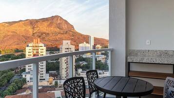 Uma varanda com vista para montanhas e paisagem urbana.