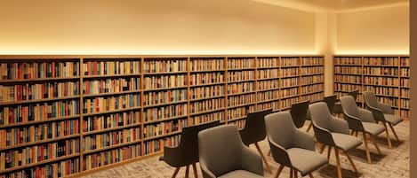 A library with rows of bookshelves and several chairs.