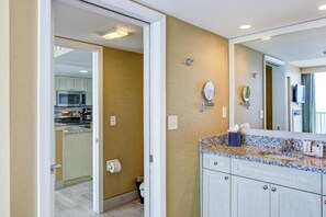 A bathroom with a sink, mirror, and toilet. - Virginia Beach | Ocean View Getaway | Pool & Beach | 2BR (Virginia Beach)