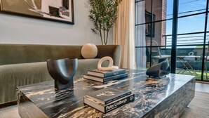 A modern living room with a marble coffee table, books, and a green sofa. - Modern Loft/Walk To Stadiums/Free Parking! (Atlanta)