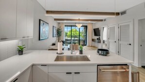 A modern kitchen with a central island, built-in appliances, and a view to the outdoors. - Modern Loft/Walk To Stadiums/Free Parking! (Atlanta)