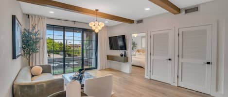 A modern living room with a sofa, a coffee table, and a TV mounted on the wall.