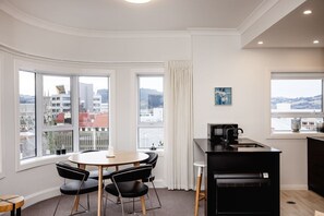 Et moderne køkken med spiseplads, store vinduer og udsigt over byen.