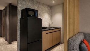 A compact kitchen with a black refrigerator, a microwave, and a sink. - Minn Ueno Iriya East (Taito)