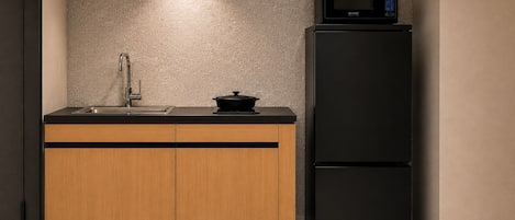 A kitchen with a sink, a microwave, and a refrigerator.