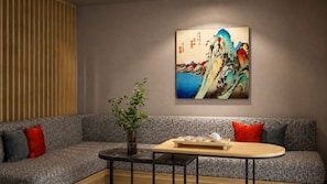 A modern living room with a sofa, a small round table, and a wall-mounted painting. - Minn Ueno Iriya East (Taito)