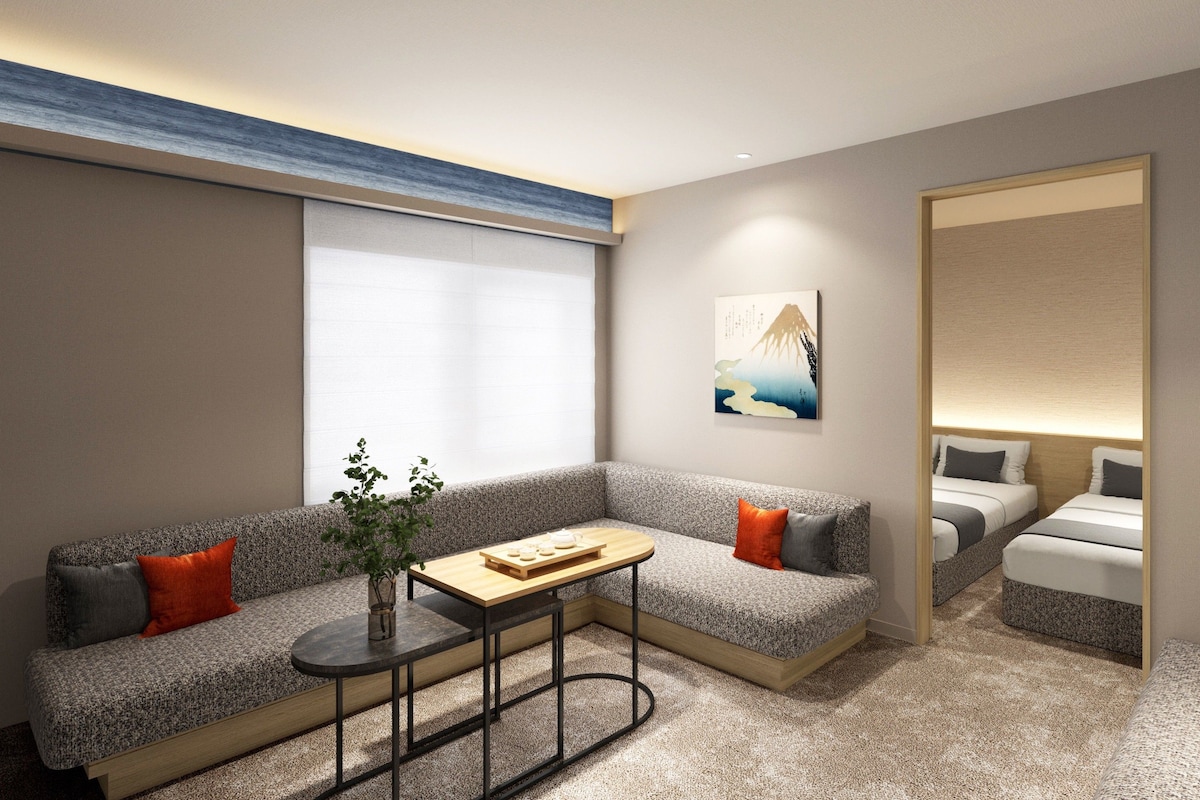 A modern hotel room with a sofa, a small table, and a bed.