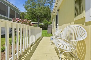 A pathway leading to a white metal bench with a yellow building in the background. - Salt & Summit Coastal Cottage - Ogunquit Escape (Ogunquit)