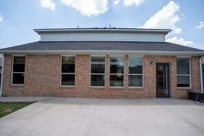 A two-story brick building with a flat roof, large windows, and a visible door.