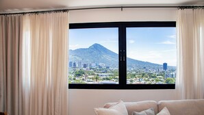 A room with a large window, a sofa, and curtains.