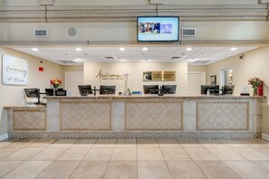 Una recepción de hotel con un televisor de pantalla plana, un letrero del Hilton Grand Vacations Club y un cartel que indica el cuarto piso.