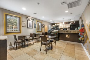 A cafe with a counter, chairs, and framed artwork on the wall. - Myrtle Beach | Family Oceanfront Getaway | Pool + Beach | 3BR Sleeps 8 (Myrtle Beach)