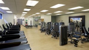 Ein Fitnessstudio mit Laufbändern, Kraftgeräten und Übungsbällen.