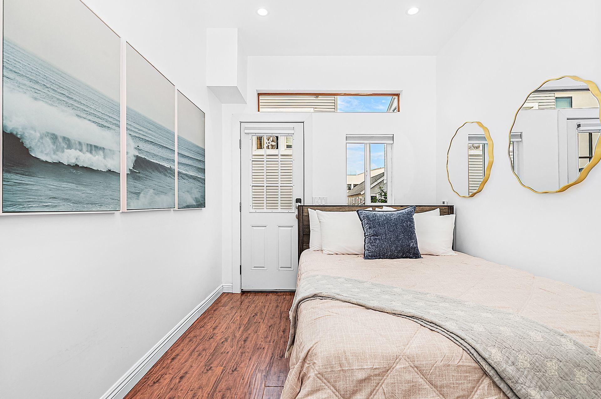 Un dormitorio con cama, armario, ventana y espejo.