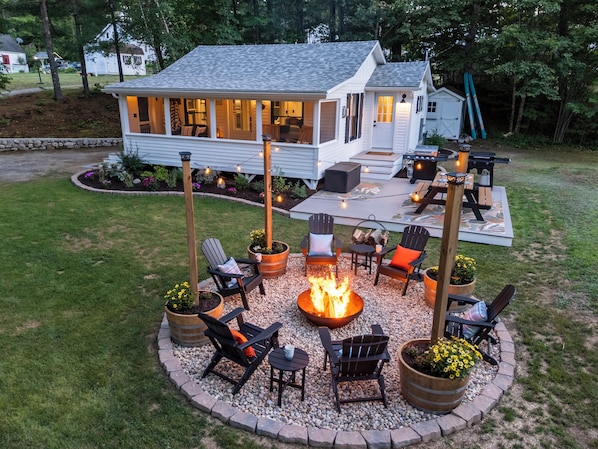 A house with a patio area featuring outdoor seating and a fire pit.