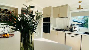 A modern kitchen with a central island, stainless steel appliances, and a large window.