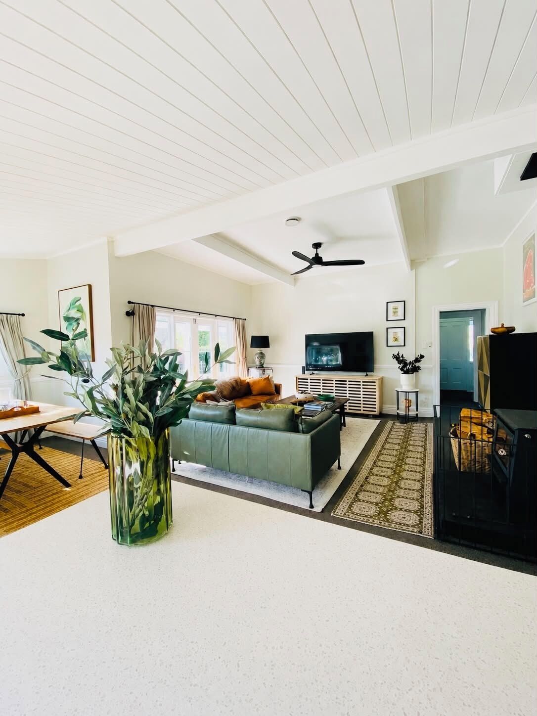 A spacious living room with a sofa, a television, and a fireplace.