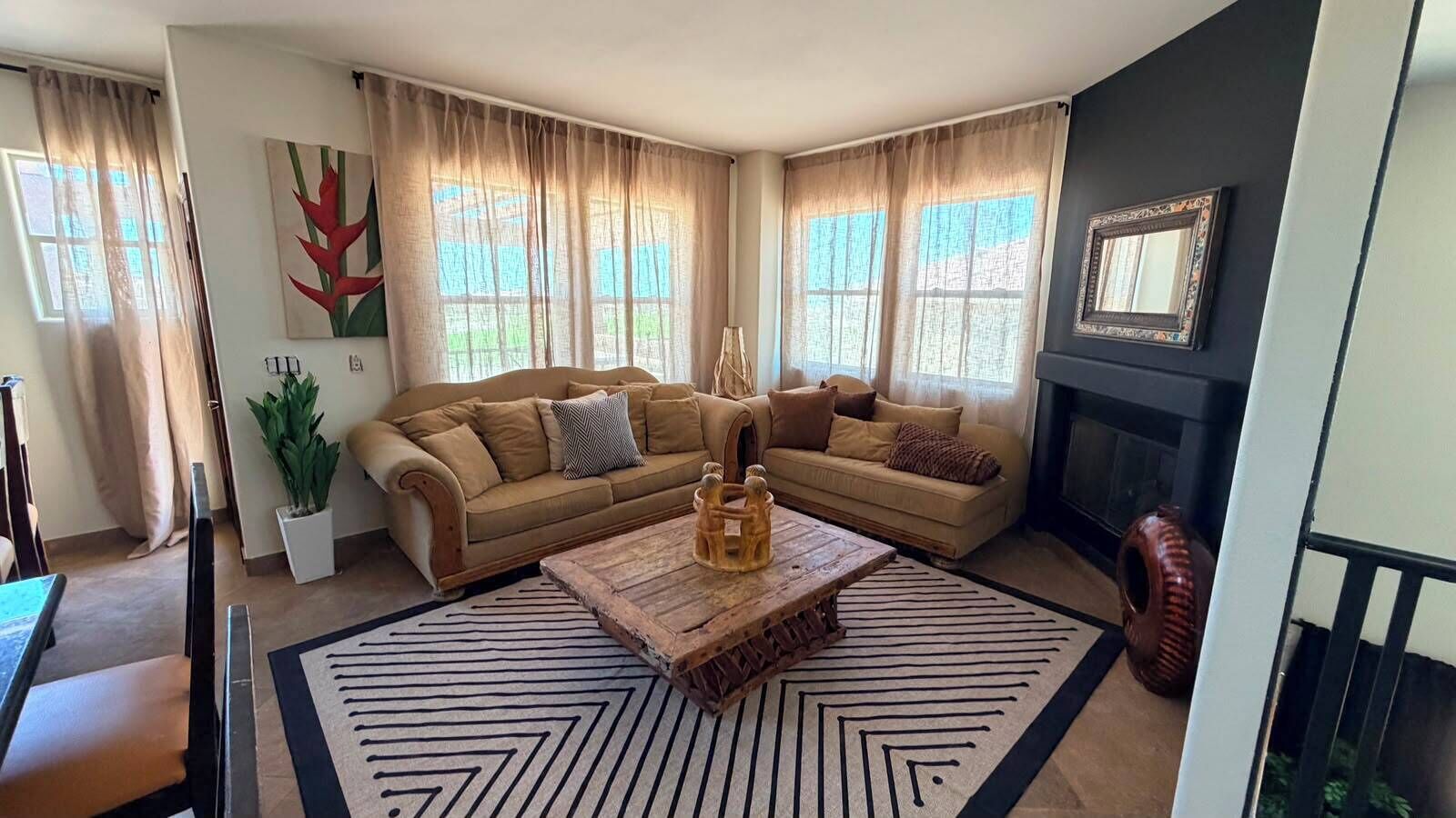 A living room with a sofa set, a coffee table, and a fireplace.