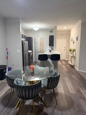 A modern kitchen with dark cabinets, a refrigerator, and a white countertop. - Home away from home (Atlanta)