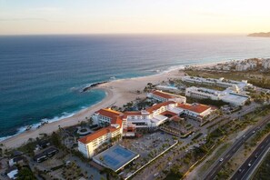 An aerial view of a coastal hotel with multiple buildings, a beach, and a road. - Los Cabos | Elevated Coastal Stay | Pool + Beach (Los Cabos)