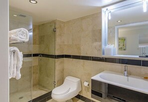 Ein modernes Badezimmer mit einer einteiligen Duschkabine, einer Toilette und einer großzügigen Badewanne.