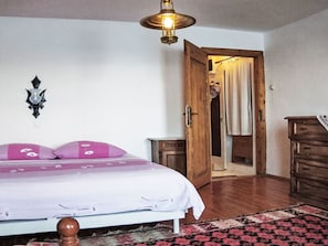 A bedroom with a bed, a nightstand, a wooden wardrobe, a mirror, and a door leading to a bathroom. - Rovinj, Magic Peninsula by Interhome (Rovinj)