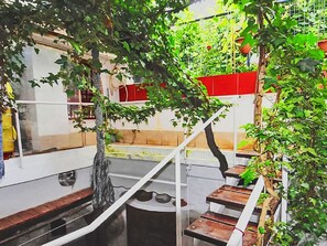 A staircase with a metal railing, surrounded by greenery and a red wall. - Rovinj, Magic Peninsula by Interhome (Rovinj)