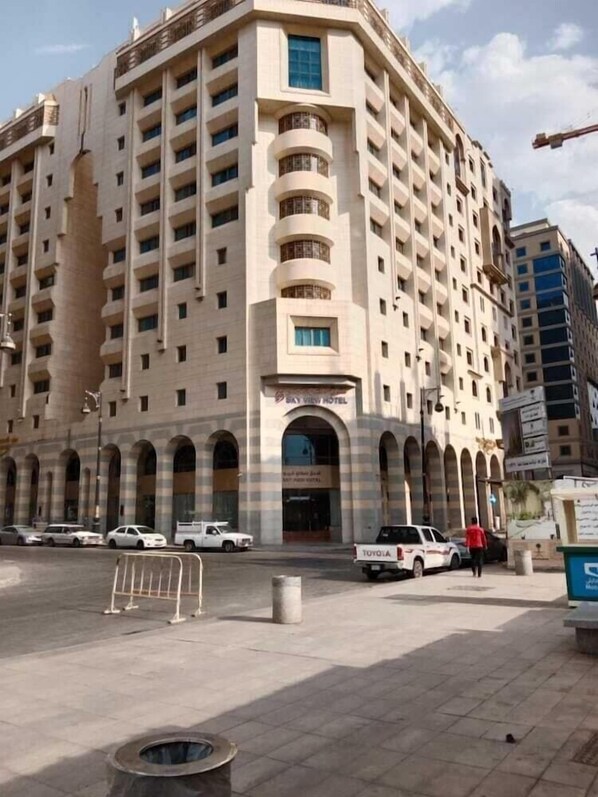 A multi-story hotel with a central arched entrance, multiple balconies, and a flat facade. - Sky View Hotel (Madinah)