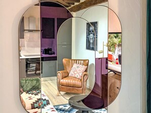 Ein Wohnzimmer mit Ledersessel, gestuhltem Hocker und rundem Tisch.