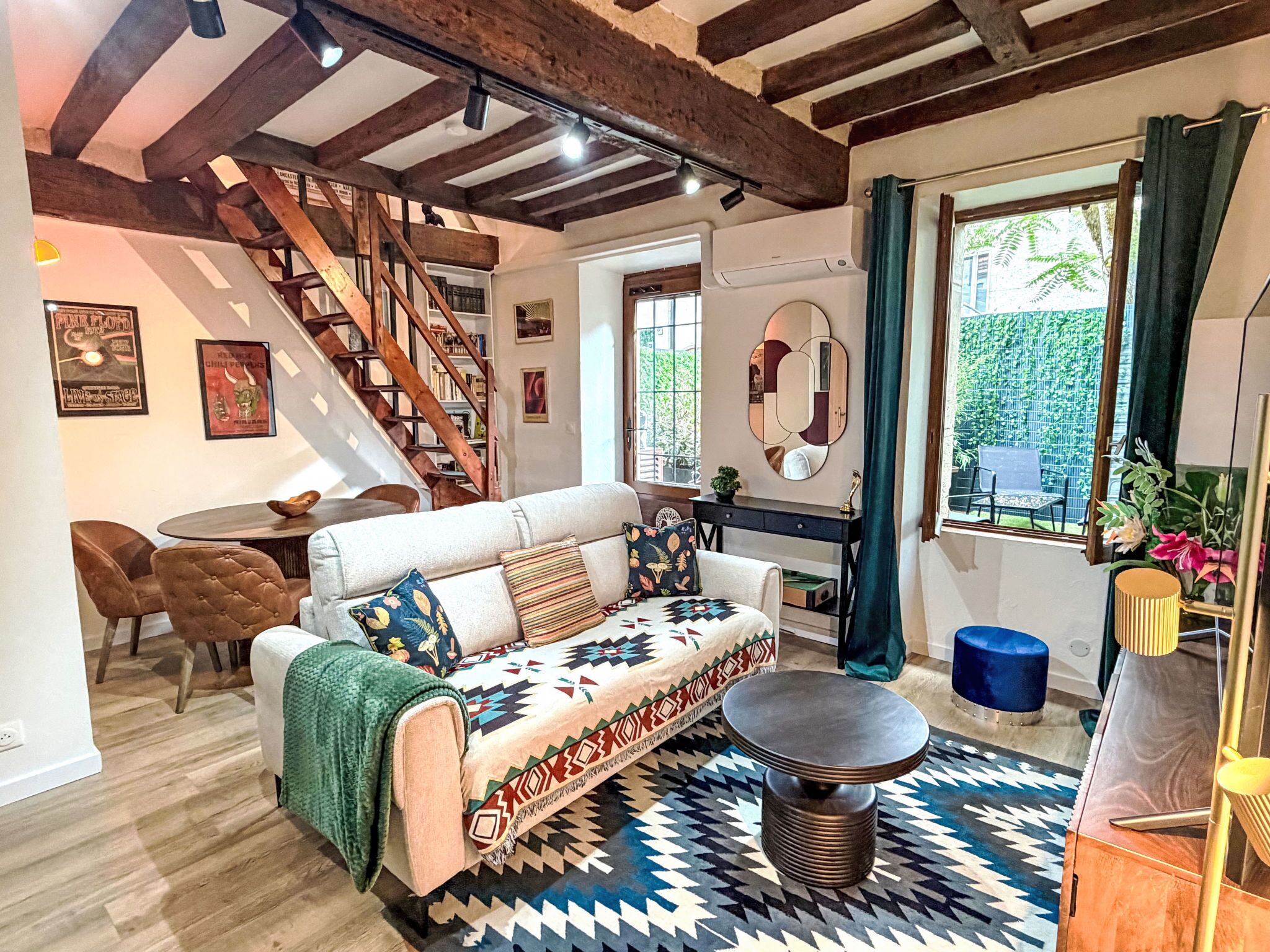 A cozy living room with a sofa, coffee table, and a staircase.