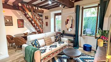 A cozy living room with a sofa, coffee table, and a staircase.