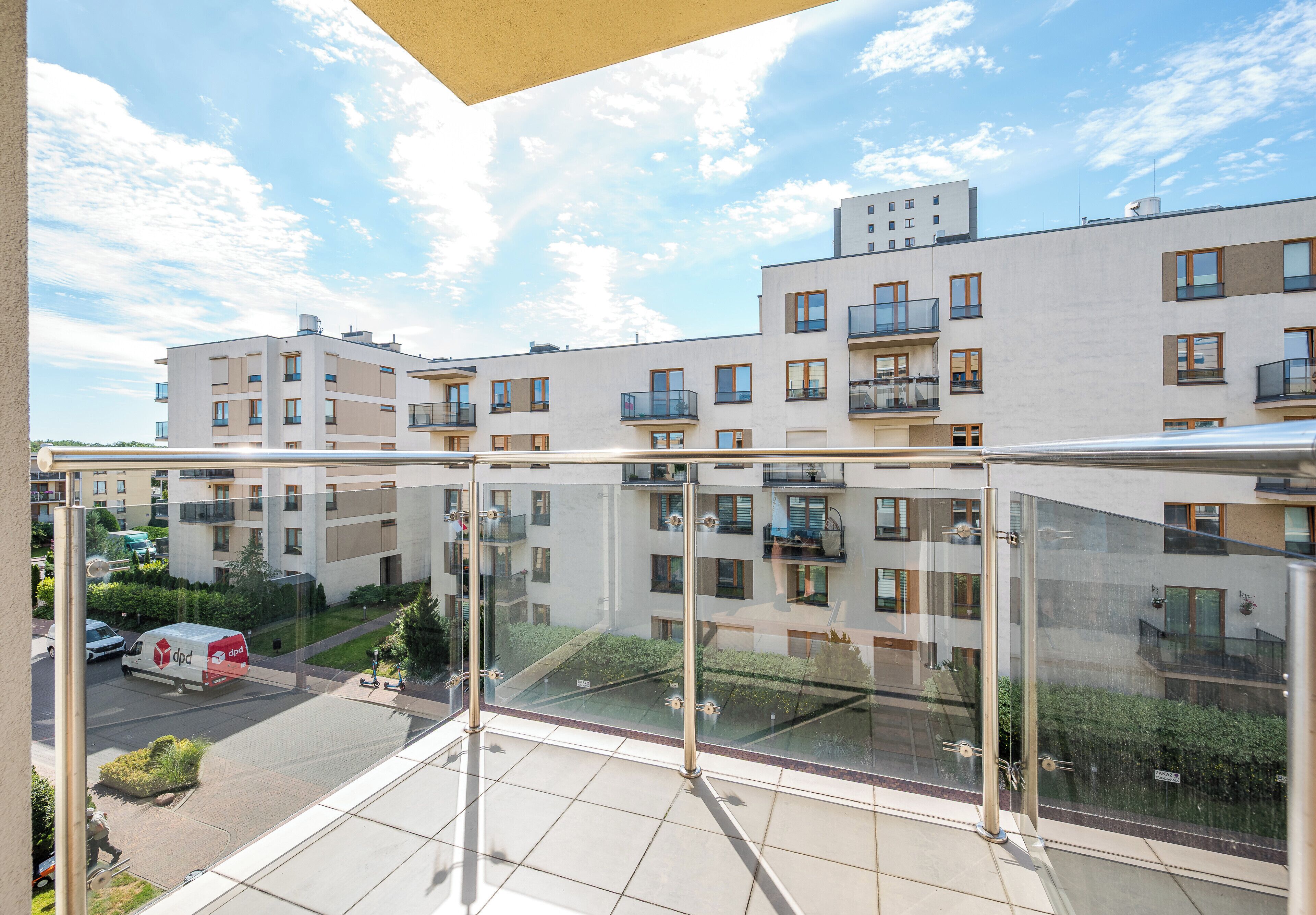 A modern apartment building with multiple balconies and a clear sky.