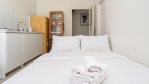 Hotellihuone, jossa on sänky, kylpyhuone ja pieni keittiötila.