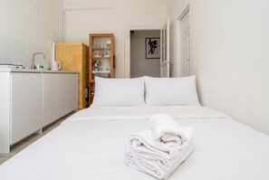 Ein Hotelzimmer mit Bett, Bad und Küchenbereich.