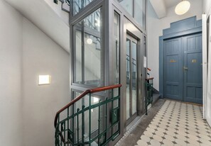 A modern interior with a staircase, a blue door, and patterned flooring. - Topolowa Comfort Apartment (Kraków)