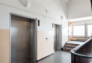 A corridor with two elevators and a staircase leading to an upper floor. - Zgoda 13 Modern City Apartment (Warszawa)