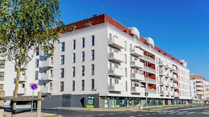 Ein mehrstöckiges Wohnhaus mit Balkonen, einem Verbotsschild und blauem Himmel.