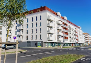 Ein mehrstöckiges Wohnhaus mit Balkonen, einem Verbotsschild und blauem Himmel.