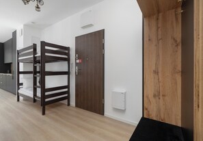 A bunk bed in a room with a wooden door and a white wall. - Zielonego Mostu Cozy Elegant Apartment (Szczecin)