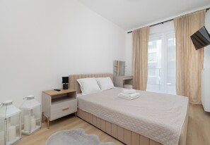 A modern bedroom with a bed, bedside tables, a mirror, and a window with curtains. - Zielonego Mostu Cozy Elegant Apartment (Szczecin)