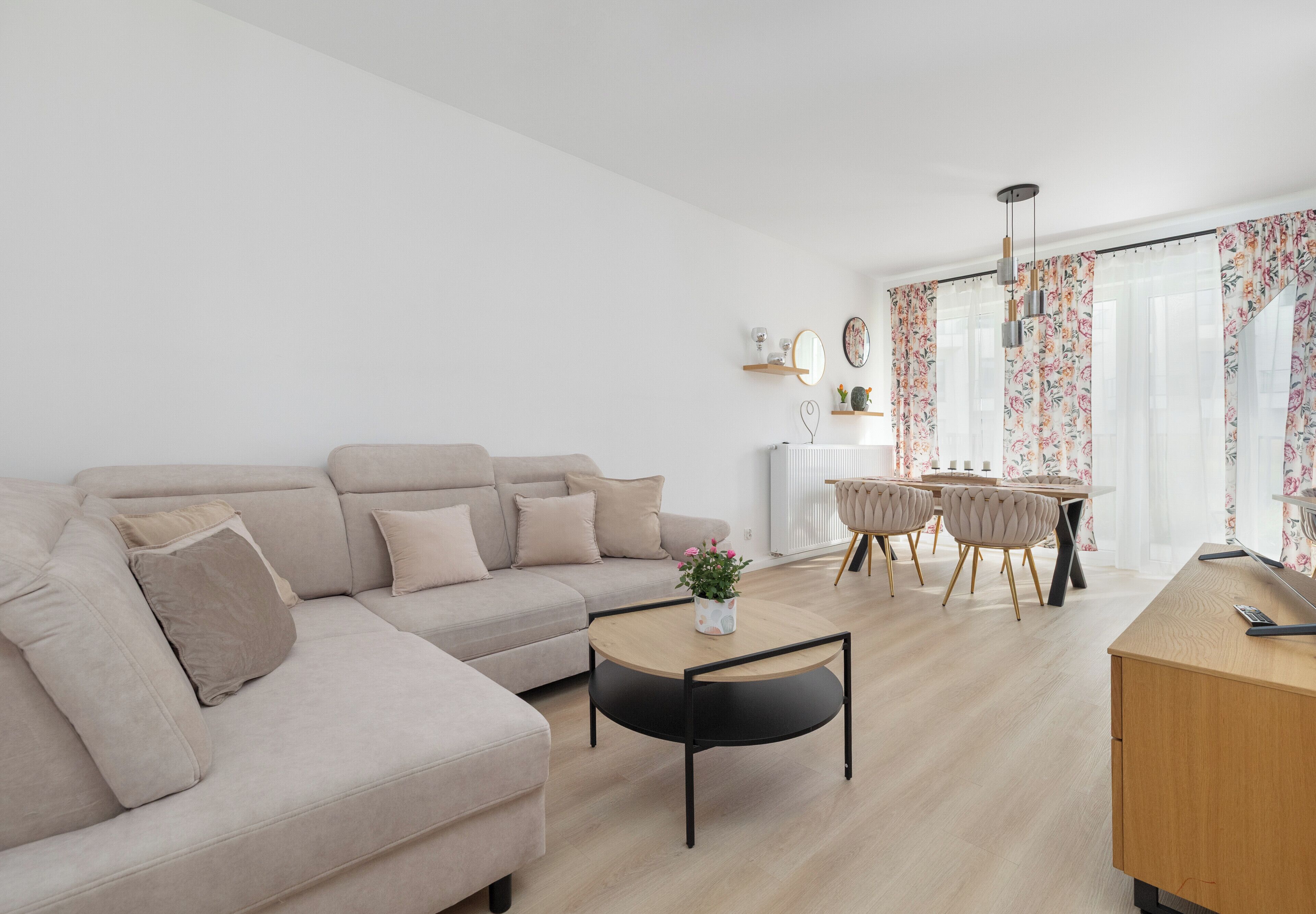 Un salon moderne comprenant un canapé, une table basse et un coin repas avec des chaises et une table.