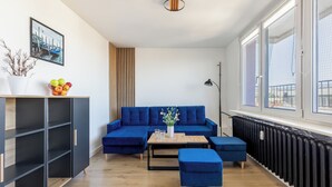 Una sala de estar moderna con un sofá azul, una mesita y una planta en maceta.
