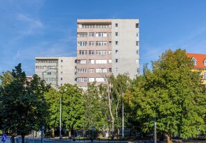 A multi-story residential building with a flat facade, multiple windows, and balconies. - Asnyka Navy Wood Apartment (Szczecin)
