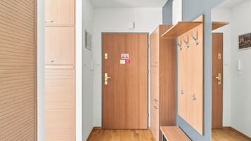 Un pasillo con taquillas de madera, una puerta con un letrero y un banco.