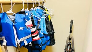 Ein Schrank mit aufhängenden Taschen und einem Staubsauger.