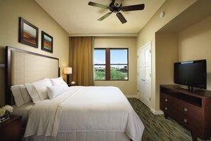Une chambre d’hôtel équipée d’un lit, d’une télévision, d’un ventilateur de plafond, d’une fenêtre avec vue et d’une porte.